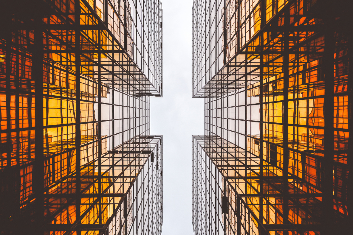 Decorative photo of the sky taken from the perspective of being between 2 identical buildings looking up