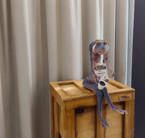 Alien GIF sitting on a box, drinking coffee