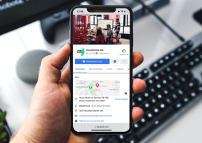 Phone with Cocomore Facebook page on the screen